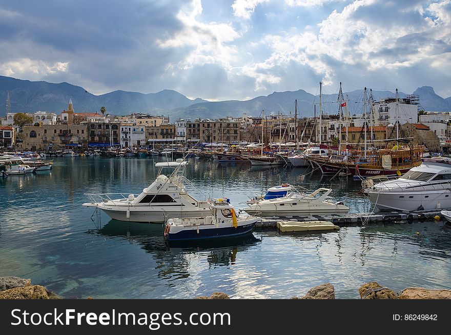 A harbor with yachts and sailboats under cloudy skies. A harbor with yachts and sailboats under cloudy skies.