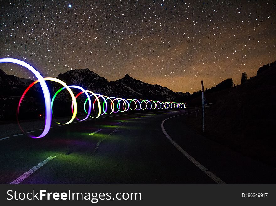 A road with light trails under the starry skies. A road with light trails under the starry skies.
