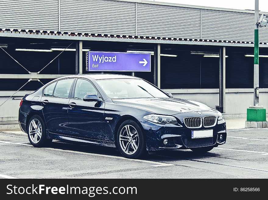 Black luxury BMW sedan parked in lot on sunny day. Black luxury BMW sedan parked in lot on sunny day.