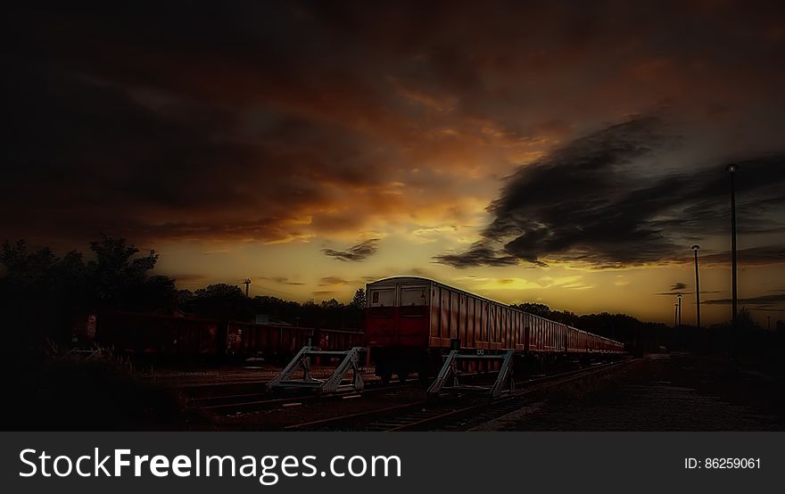 Red and White Train Taken during Sunset
