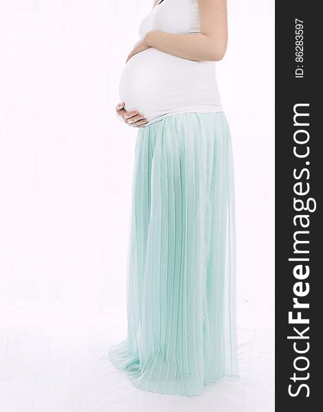 Pregnant Woman Standing in Front of White Wall