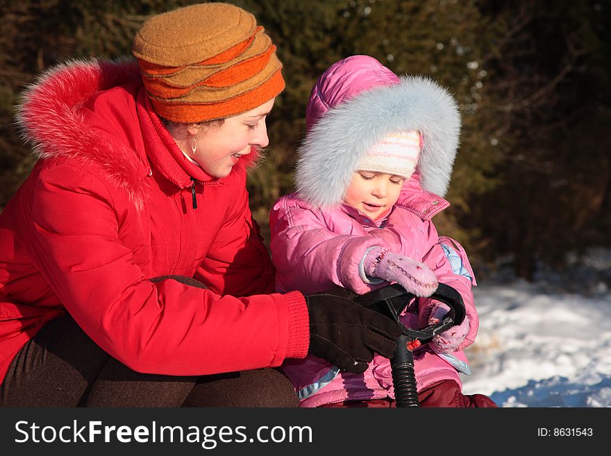 Mother and daughter with snow scooter, winter