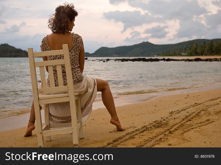 Woman to sit on the chair at sunset. Woman to sit on the chair at sunset