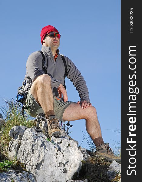 A handsome middle age hispanic latin man in a top of a in mountain hiking with a backpack. A handsome middle age hispanic latin man in a top of a in mountain hiking with a backpack