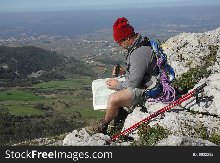 A handsome middle age hispanic latin man in a top of a in mountain hiking with a backpack looking the field with a googles. A handsome middle age hispanic latin man in a top of a in mountain hiking with a backpack looking the field with a googles