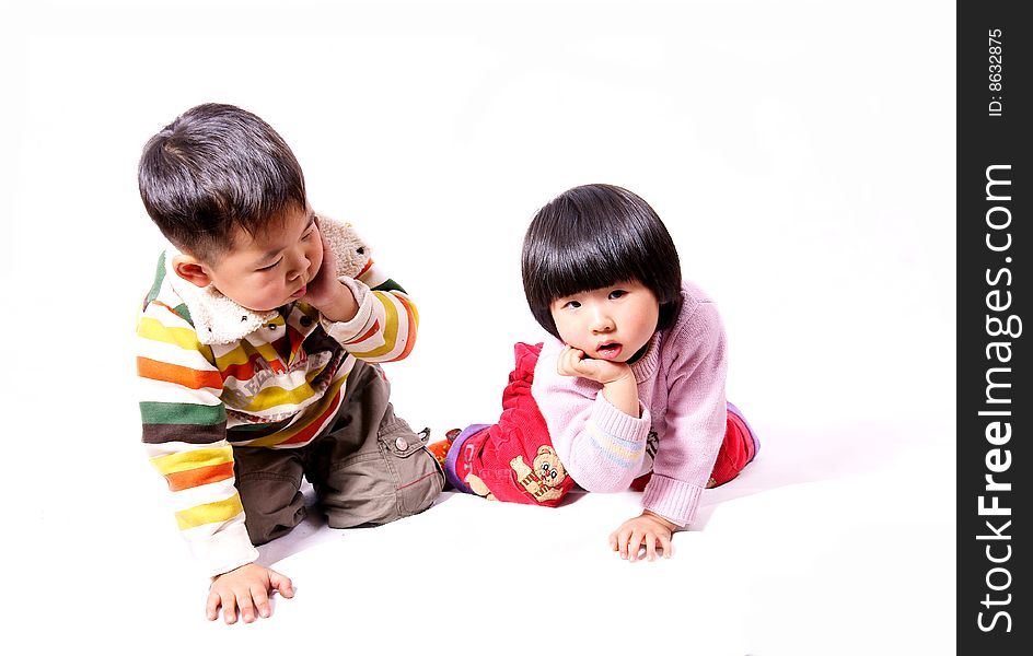 A picture of a little chinese boy and girl playing together with hand supporting chin