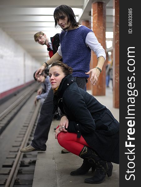 Group of young friends on edge of platform of subway station. Group of young friends on edge of platform of subway station
