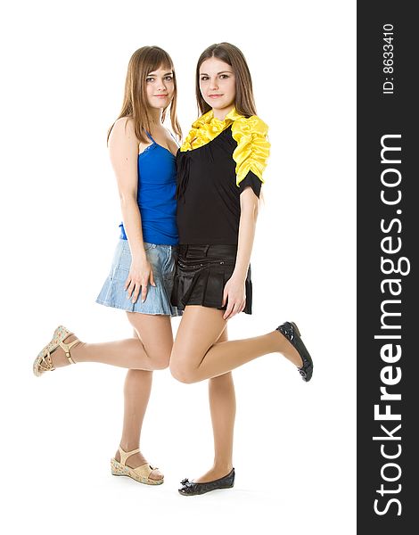 Two girls with raised leg isolated on white background