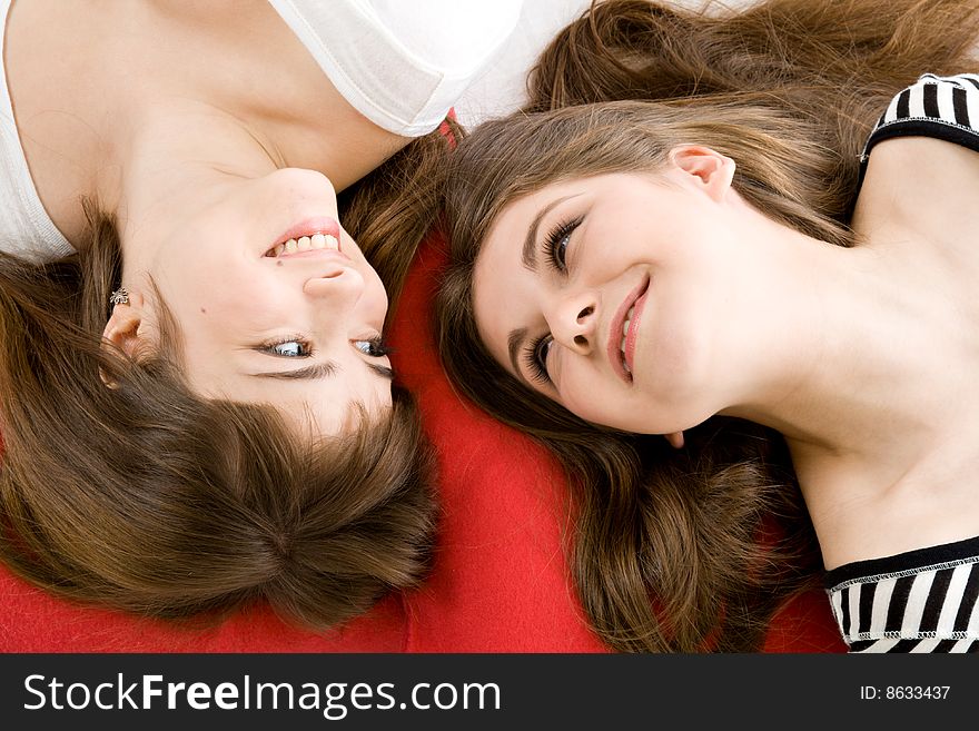 Two girls lying on red pillow