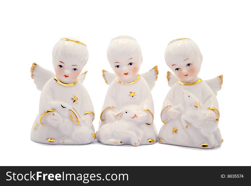 Three porcelain angels with rabbit, lamb and piglet. Isolated on white.