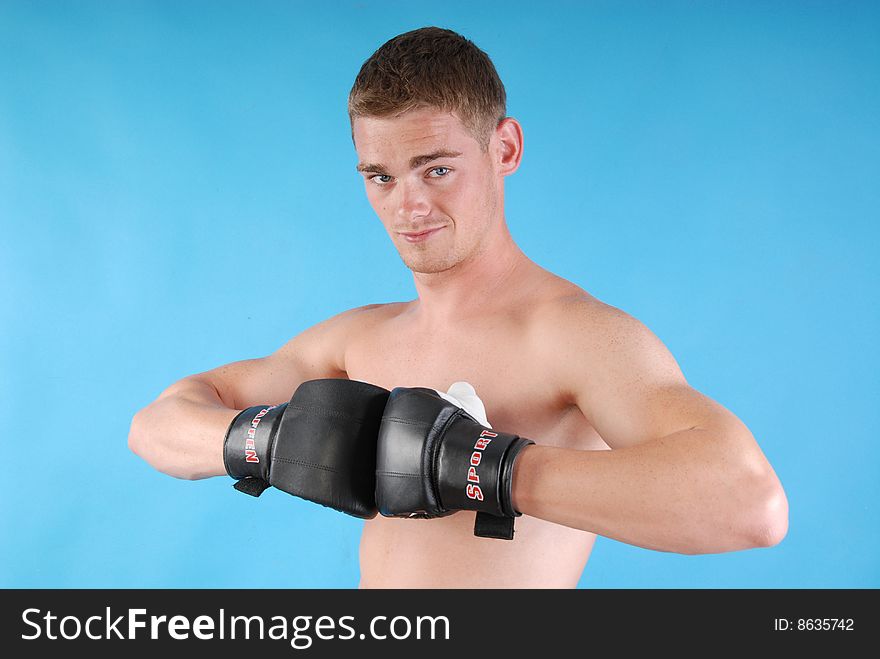 Young adult with boxing gloves against blue background. Young adult with boxing gloves against blue background