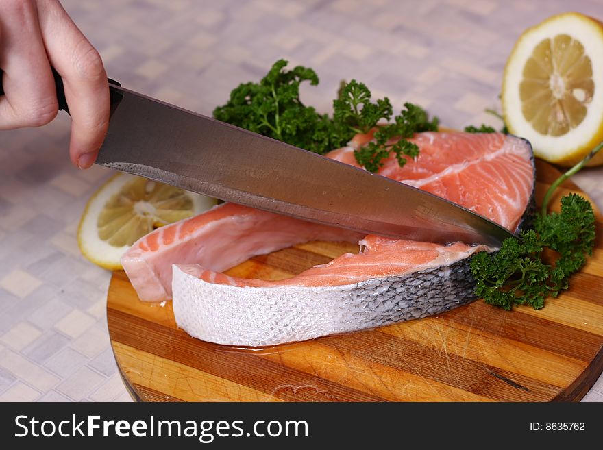 Fresh slice of salmon with lemon and green parsley