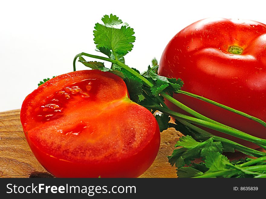 Tomato and coriander on a wooden plate