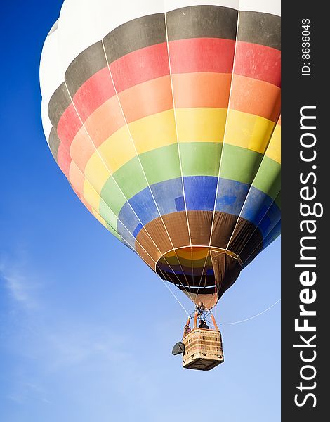 Unrecognizable people traveling in a multicolor balloon. Unrecognizable people traveling in a multicolor balloon