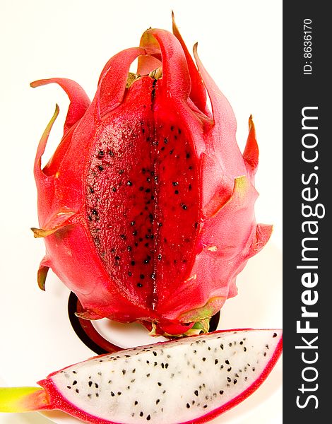 An exposed red Dragon fruit contrasted to a white one