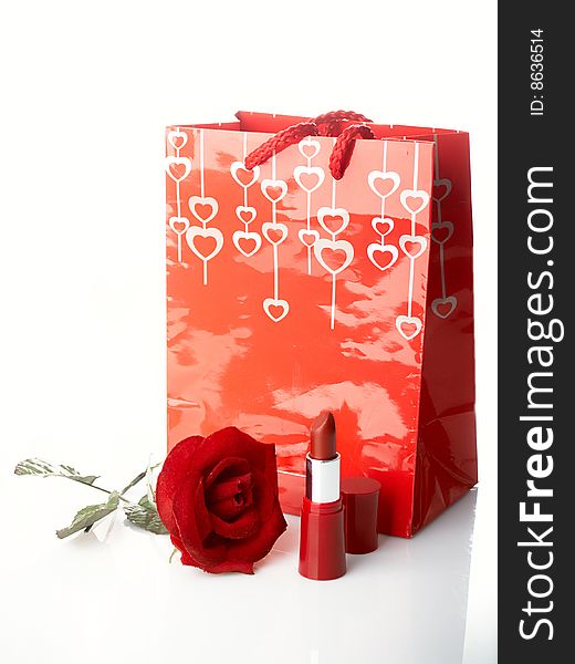 Celebratory close from a rose , package and lipstick. Celebratory close from a rose , package and lipstick