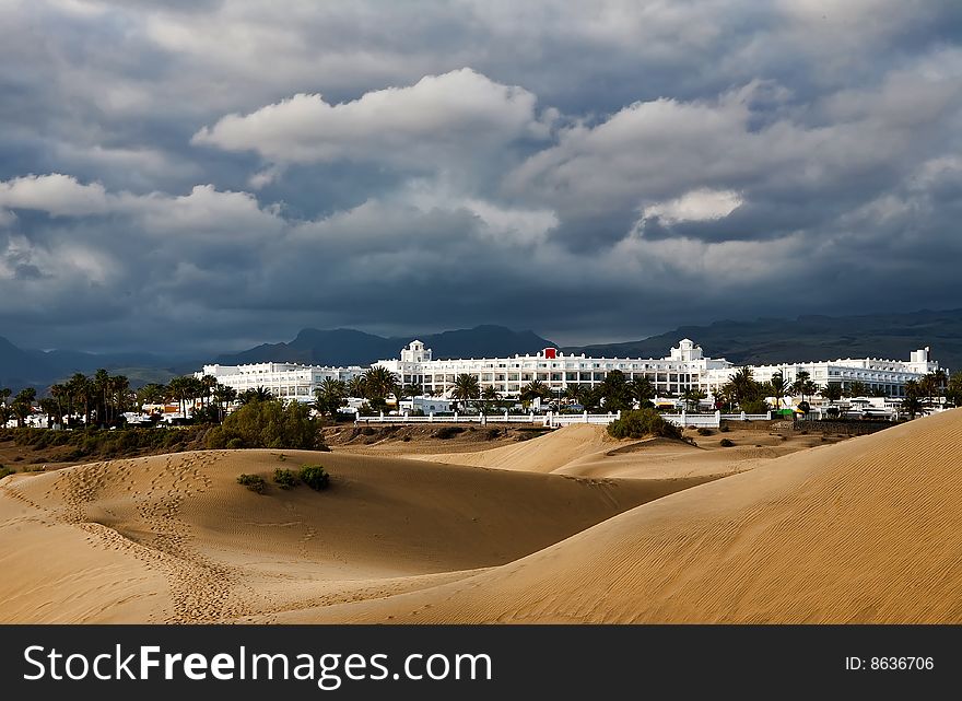 Beautiful resort beach near the desert dunes under dramatic cluods. Beautiful resort beach near the desert dunes under dramatic cluods