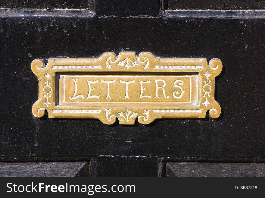 Old brass letterbox with the word letters engraved on it