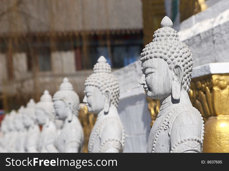 Stone buddha statue near by white pagoda