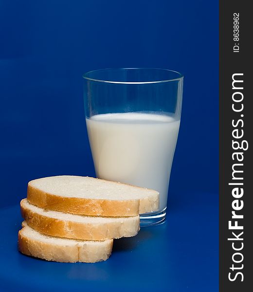 A glass of milk and toastes on a blue background. A glass of milk and toastes on a blue background