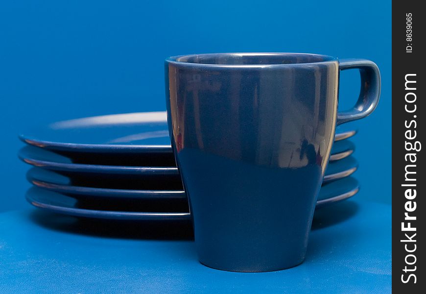 Blue coffee mug and the stack of plates. Blue coffee mug and the stack of plates