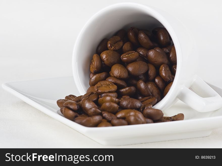 Coffee and beans inside a white porcelain cup