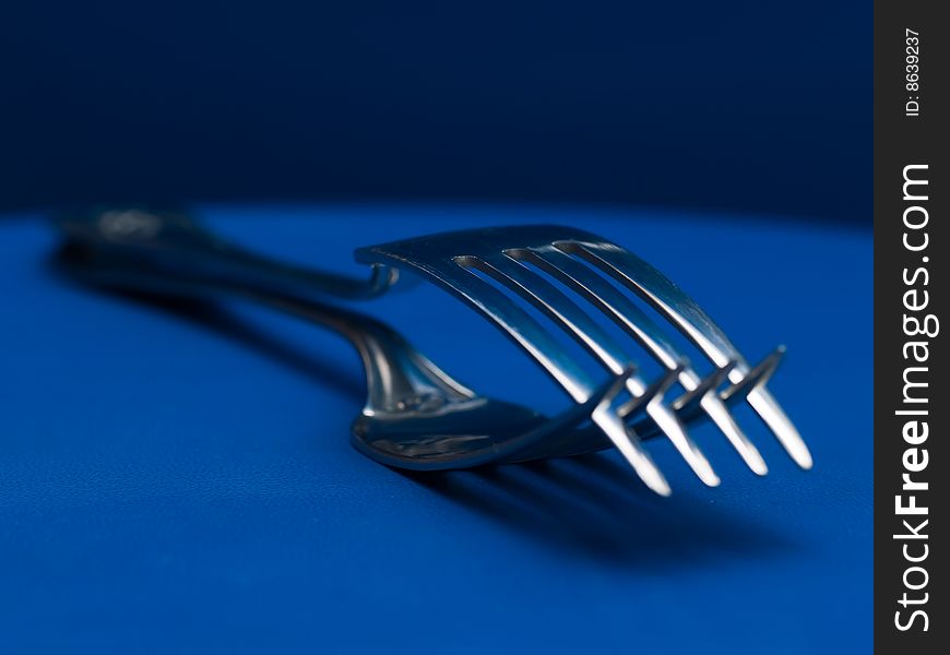Forks crossing teeth on blue background. Forks crossing teeth on blue background