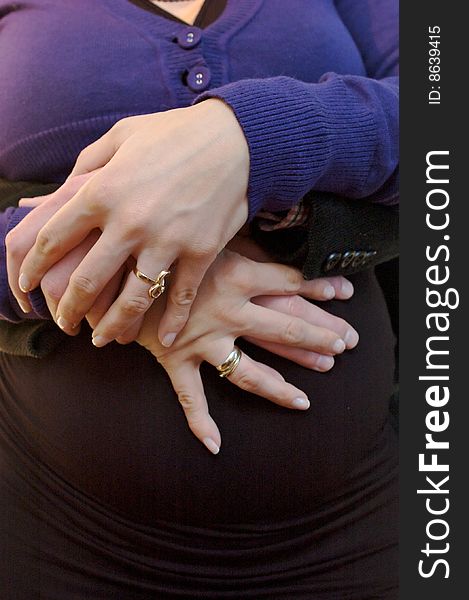Hands closeup of a pregnant girl wearing fancy jewelerry