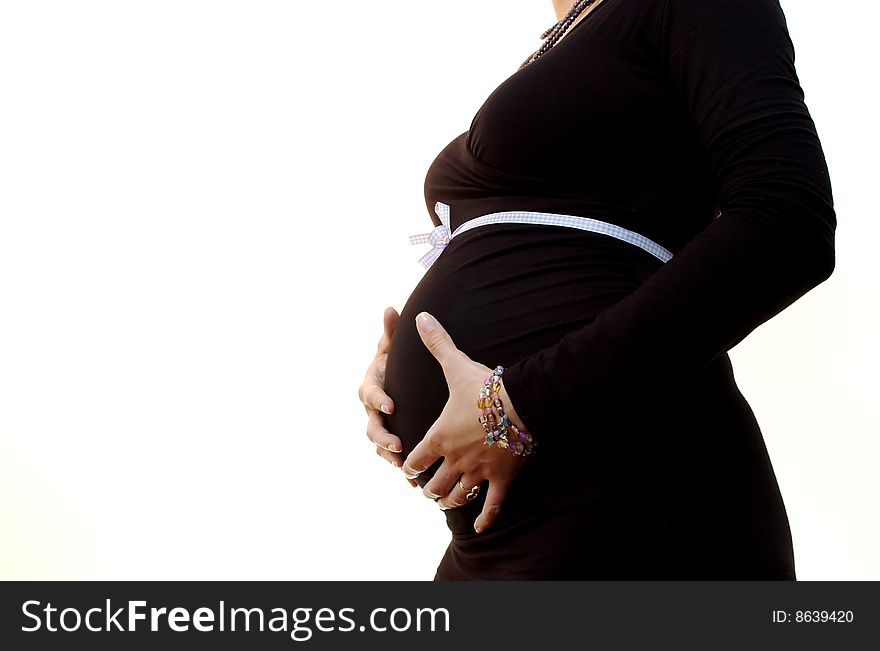 Body closeup of a fancy dressed pregnant girl hoding her belly isolated on white. Body closeup of a fancy dressed pregnant girl hoding her belly isolated on white