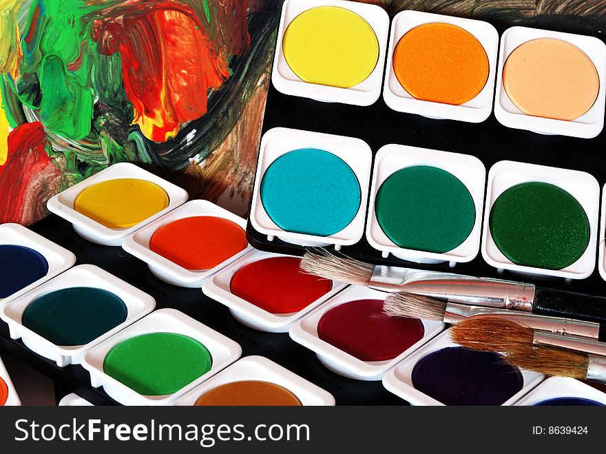 Four brushes on top pf  a pile of painting colors for children and colorful background. Four brushes on top pf  a pile of painting colors for children and colorful background