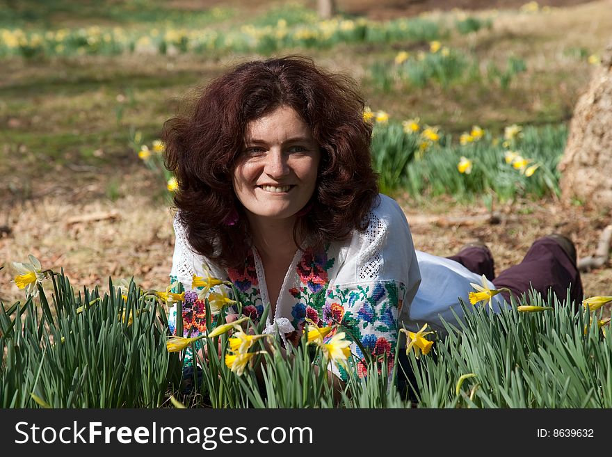 Smiling girl lie on a meadow with flowering daffodil. Smiling girl lie on a meadow with flowering daffodil