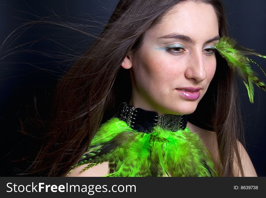 Portrait beautiful woman with blowing hair and green feathers. Portrait beautiful woman with blowing hair and green feathers