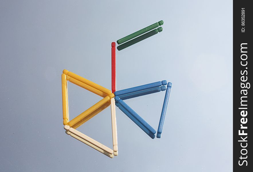 Color sticks on mirror surface forming colorful triangles.