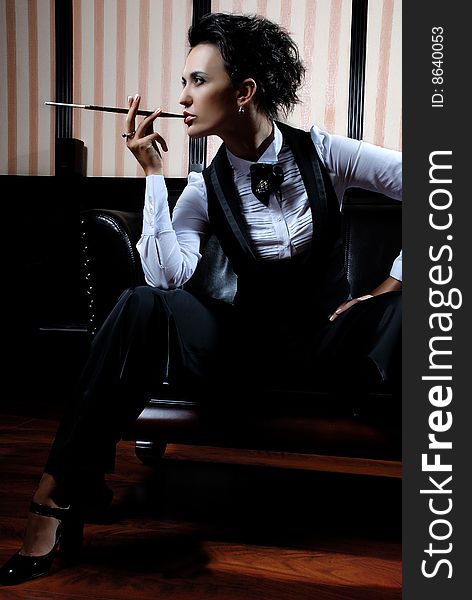 Woman on the striped background wearing business clothes, smoking. Woman on the striped background wearing business clothes, smoking.