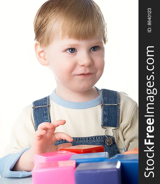 The child the boy plays cubes on a white background