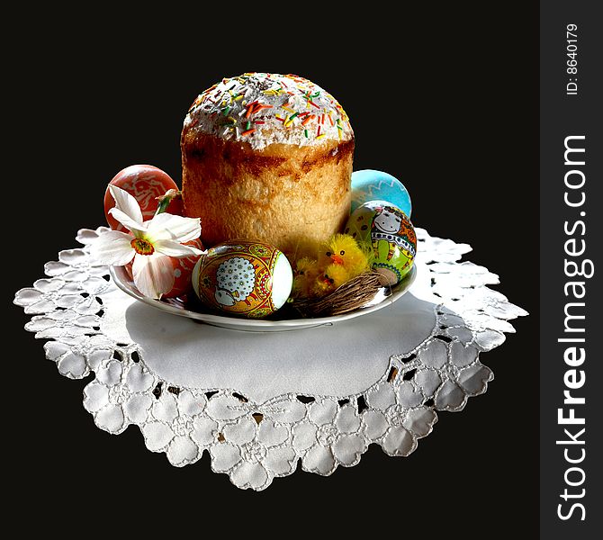 An image of an easter cake on a plate with eggs and flower