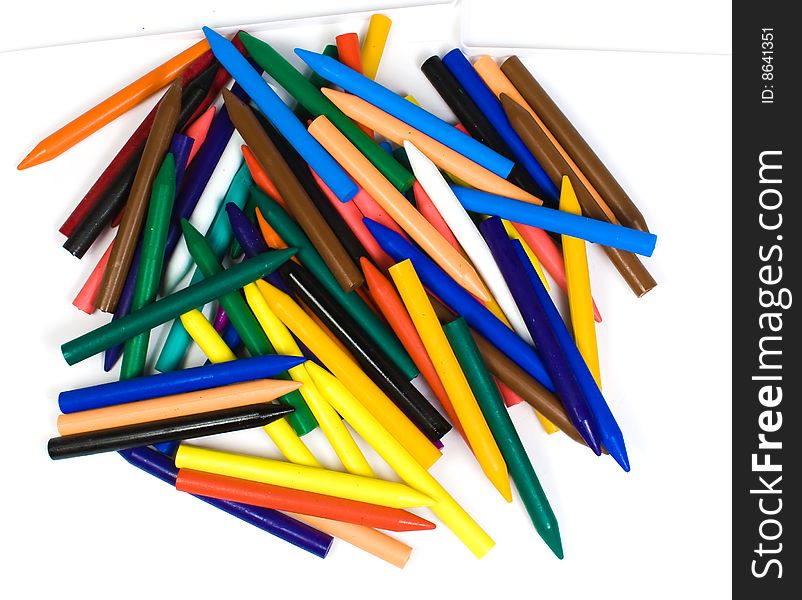 The top view on a chaotic heap of color wax pencils. The top view on a chaotic heap of color wax pencils
