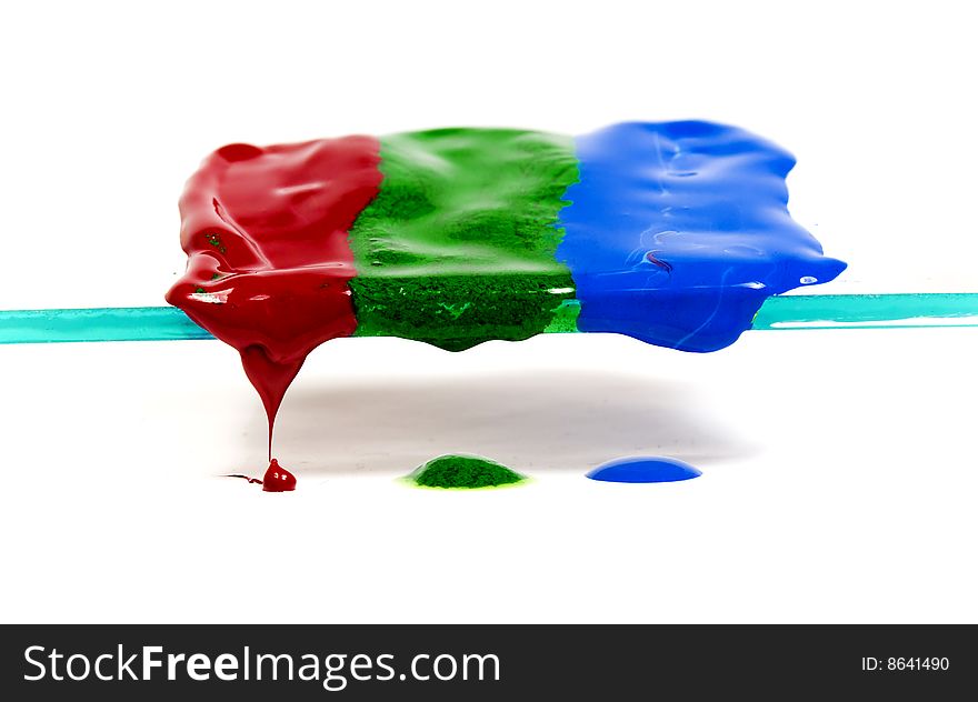 Three strips of thawing and dripping wax of red, dark blue and green colors