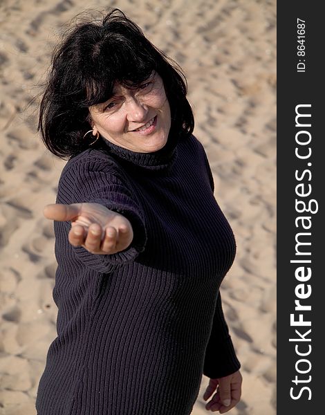 Happy woman, dressed in the dark background of sand. Happy woman, dressed in the dark background of sand.