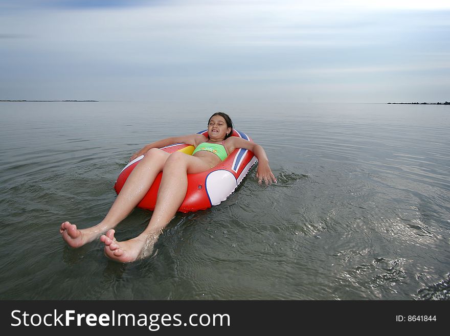 Little girl sitting on inflatable boat on sea. Little girl sitting on inflatable boat on sea