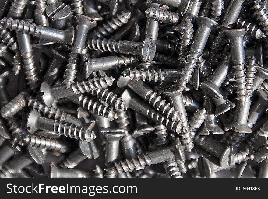 Close-up shot of a group of screws. Grey colour. Black and white. Close-up shot of a group of screws. Grey colour. Black and white.