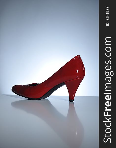 Red high heel shoe on a table, close up. Red high heel shoe on a table, close up