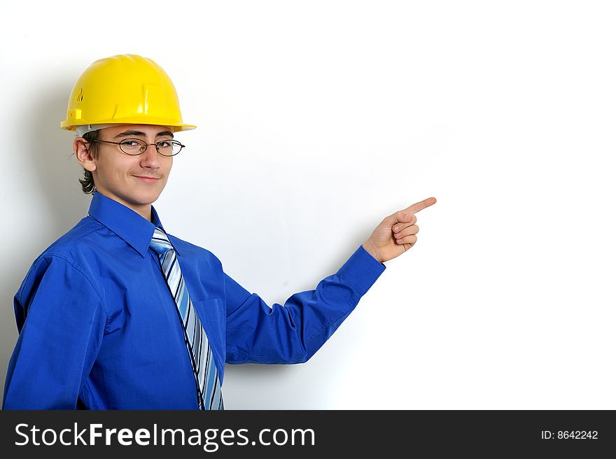 Young engineer wearing hard hat pointing on white background. Young engineer wearing hard hat pointing on white background