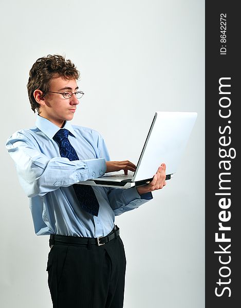 Young businessman standing up and using computer. Young businessman standing up and using computer