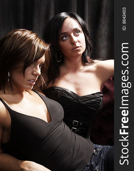 Two woman posing on a serious way. high contrast lightning. Two woman posing on a serious way. high contrast lightning.