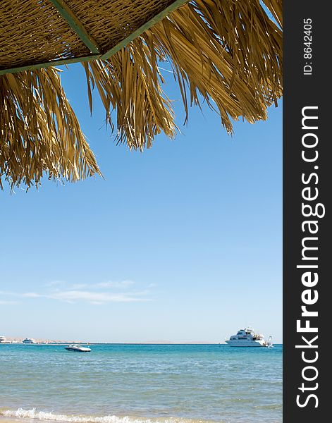 Under sunshade with view on turquoise sea with yachts