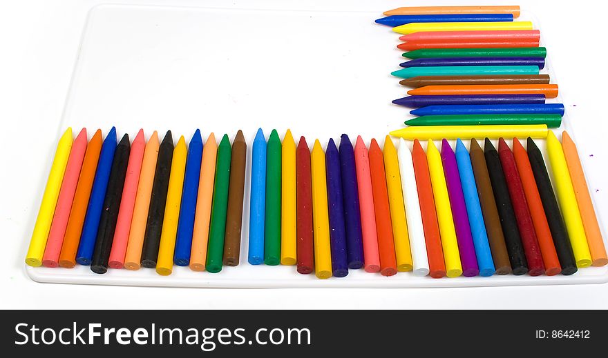Many wax pencils on a white plastic board