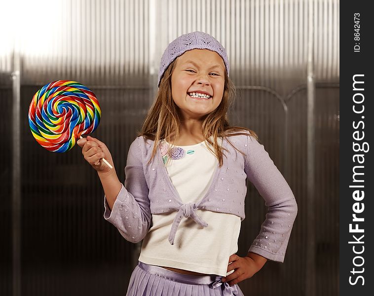 Cute young girl with lollipop and knit cap