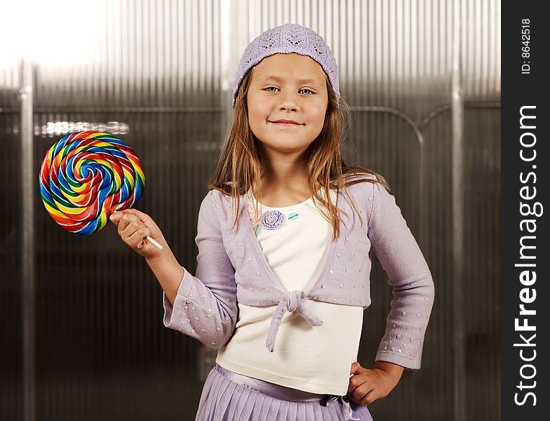 Cute young girl with lollipop and knit cap