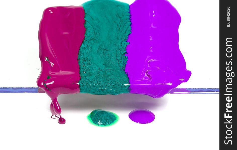 Dripping wax of three colours on transparent glass
